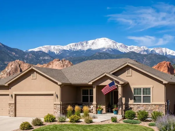 For-sale sign in front of a well-maintained home in a Colorado Springs neighborhood with mountain views