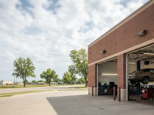 Auto technician in shop uniform explaining a repair diagnosis to a customer at a service counter in Wichita, KS