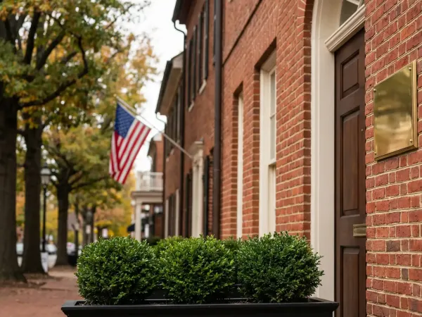 Professional financial advisor in a well-appointed consultation office in Alexandria, VA meeting with a client at a polished desk with portfolio documents visible