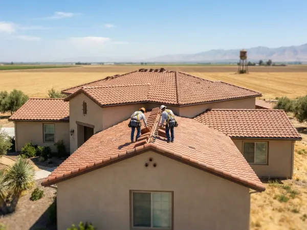 Roofing contractor inspecting a clay tile roof on a Spanish-style stucco home in Visalia, CA, with blue Central Valley sky in background