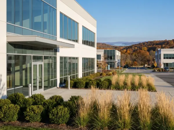 Modern dental office exterior in a professional medical plaza in Rogers, AR with clean white facade and welcoming front entrance under a clear blue sky
